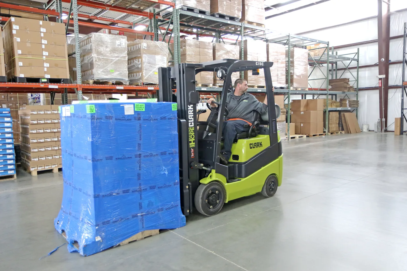 Clark C15C forklift moving a wrapped pallet past pallet racking in a Delaware warehouse